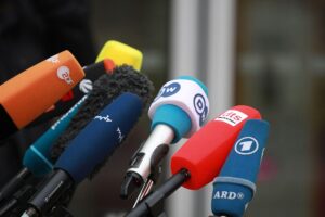 Mikrofone von Journalisten symbolisieren den Appell für fairen Schutz gegen KI-Nutzung in Medien.