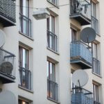 Satellitenschüssel an Wohnhaus symbolisiert aktuelle Wohnraumsituation und soziale Ungerechtigkeiten in Deutschland.
