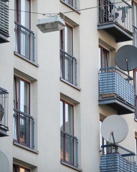 Satellitenschüssel an Wohnhaus symbolisiert aktuelle Wohnraumsituation und soziale Ungerechtigkeiten in Deutschland.