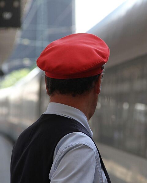 Zwei Zugschaffner im Gespräch am Bahnsteig, symbolisieren Sicherheit und Kundenbetreuung im Zug.