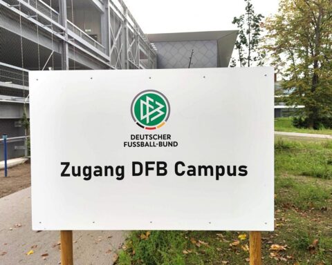 DFB-Zentrale mit Logo, Fußballbilder, TV-Geräte und junge Spieler im Training.