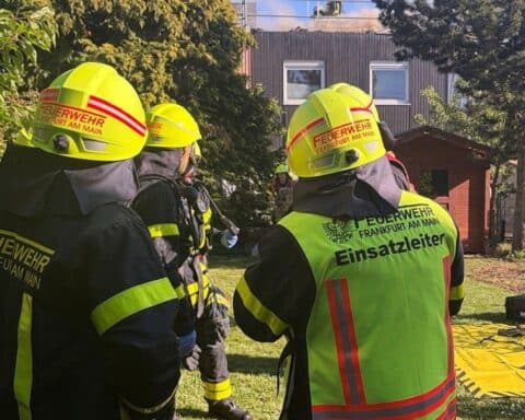 Dachstuhlbrand in Frankfurt mit Feuerwehr, Löschmaßnahmen und Einsatzkräften auf Bildern.