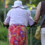 Seniorin und Helferin zeigen die Herausforderungen der alternden Bevölkerung in der Pflegeversorgung.