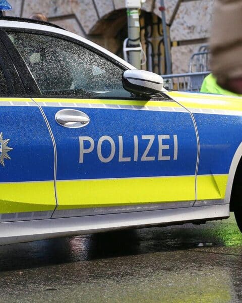 Polizeiauto vor Bahnhof, Symbol für Ermittlungen nach Angriff auf 32-Jährigen in Erlangen.