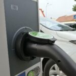 Steigende Neuzulassungen von E-Autos; Stromtankstelle symbolisiert den Wandel zur Elektromobilität.