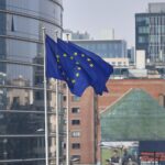 EU-Fahnen vor dem Hintergrund des Brüsseler Sitzes zeigen Unterstützung für Ukraine und Sanktionen gegen Russland.