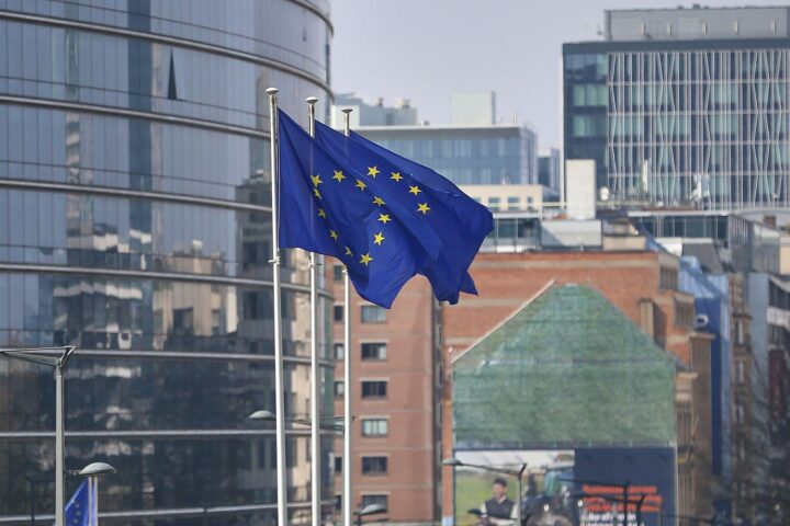 EU-Fahnen vor dem Hintergrund des Brüsseler Sitzes zeigen Unterstützung für Ukraine und Sanktionen gegen Russland.
