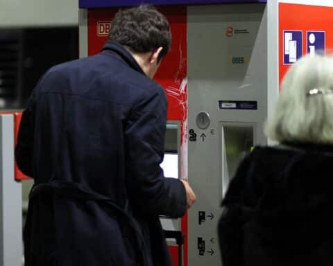 Reisender an Fahrkartenautomat, symbolisiert Diskussion um Schwarzfahren und Sicherheit im öffentlichen Verkehr.