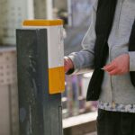 Ein Fahrgast stempelt eine Fahrkarte in einem öffentlichen Verkehrsmittel, symbolisiert Ticketkontrolle.