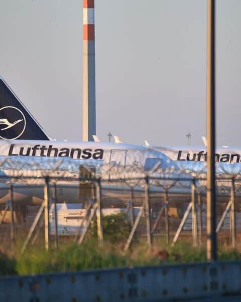 Lufthansa-Flugzeuge am Flughafen, symbolisieren steigende Ticketpreise und geopolitische Herausforderungen auf Asien-Strecken.