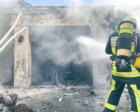 Feuerwehr löscht Garagenbrand mit Rauchentwicklung, betroffenen Pkw und Gasflaschen in Bochum.