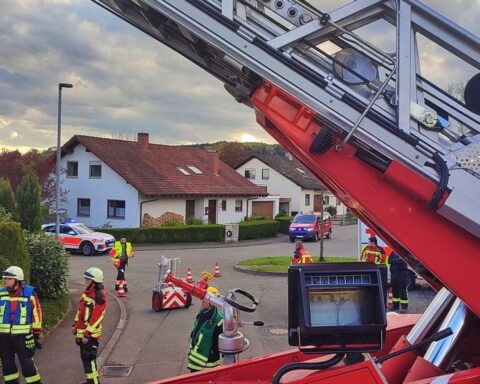 Rettungskräfte befreien Person aus tiefem Abwasserschacht, Feuerwehr und Rettungsdienst im Einsatz.