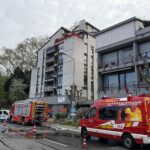Rettungsfahrzeuge der Feuerwehr blockieren die Grundelbachstraße wegen eines Wasserrohrbruchs in Weinheim.