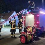 Küchenbrand in Celle: Feuerwehr löscht Feuer, Rettungsdienst betreut verletzte Person.