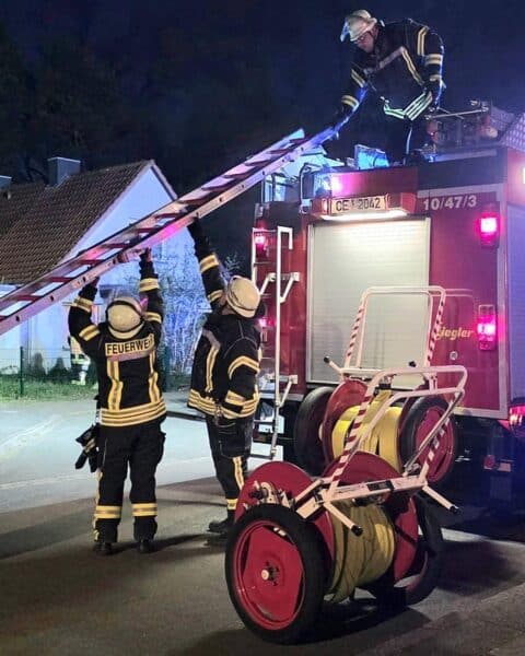 Küchenbrand in Celle: Feuerwehr löscht Feuer, Rettungsdienst betreut verletzte Person.
