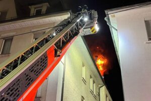 Feuerwehr löscht Dachstuhlbrand in Stuttgart-Zuffenhausen; verletzter Feuerwehrmann, betroffene Wohnungen unbewohnbar.