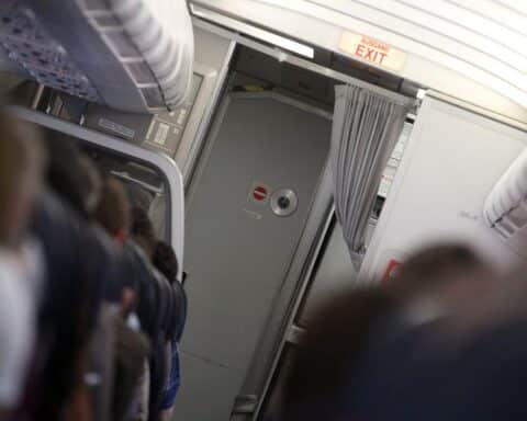 Flugzeugkabine mit Cockpit-Tür, symbolisiert Luftverkehrsbranche und bevorstehende Steuerreformen in Deutschland.