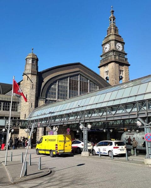 Frau mit Waschmittel in Sporttasche, Bundespolizisten und Hamburger Hauptbahnhof im Hintergrund.