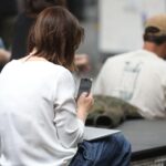 Frau nutzt Smartphone, Symbol für digitale Gesundheitsanwendungen und deren Herausforderungen im Gesundheitssystem.