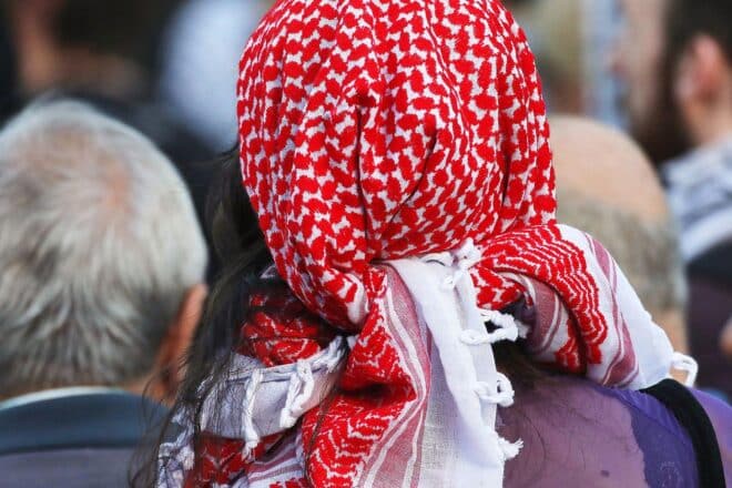 Ein Mann mit Pali-Tuch demonstriert symbolisch vor der Gedenkstätte Buchenwald.