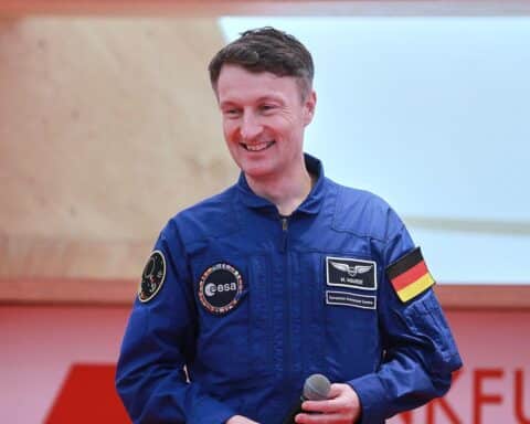 Matthias Maurer mit Raumanzug vor einer Mondlandschaft; symbolisiert Deutschlands Mondmission.