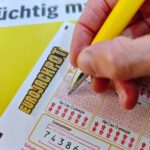 Ein Eurojackpot-Spielschein mit Gewinnzahlen und symbolischen Eurozeichen im Hintergrund.