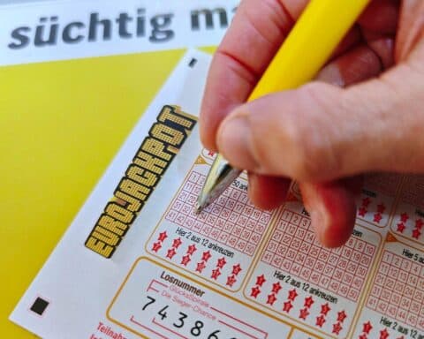 Ein Eurojackpot-Spielschein mit Gewinnzahlen und symbolischen Eurozeichen im Hintergrund.