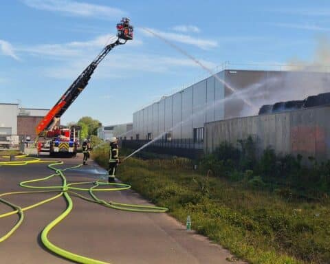 Feuerwehrleute bekämpfen Brand mit Wasserwerfern und Drehleitern an der Ruhrorter Straße.
