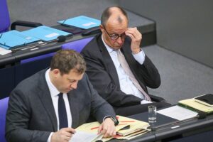 Lars Klingbeil und Friedrich Merz diskutieren über Regierungsarbeit im Bundestag, thematisiert in einem Artikel.