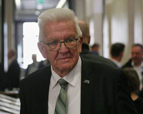 Winfried Kretschmann wird feierlich verabschiedet, umgeben von Grünen und Unterstützern.