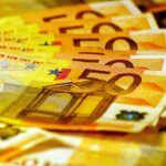 Euroscheine und Finanzdokumente, die Einnahmen aus der Bodenordnung in Hamburg symbolisieren.