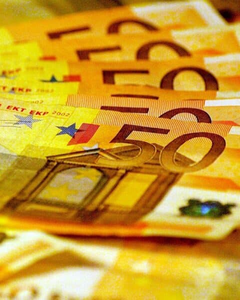 Euroscheine und Finanzdokumente, die Einnahmen aus der Bodenordnung in Hamburg symbolisieren.