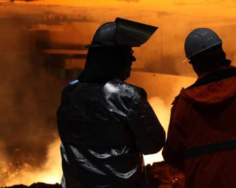 Ein modernes Bürogebäude mit Menschen, die an Computern arbeiten und internationale Zusammenarbeit symbolisieren.