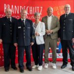 Innenminister Poseck mit Feuerwehrvertretern, betont Brandschutzerziehung für Sicherheit und Nachwuchs.