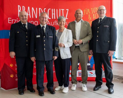 Innenminister Poseck mit Feuerwehrvertretern, betont Brandschutzerziehung für Sicherheit und Nachwuchs.