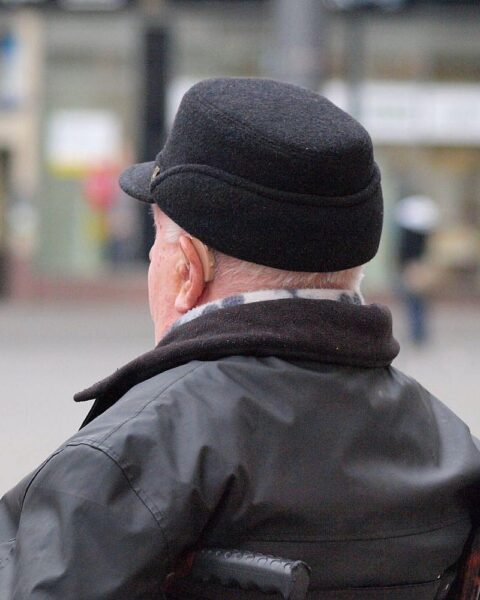 Gewerkschaftschefin kritisiert Rentenkürzungen, protestbereite Beschäftigte, Mann im Rollstuhl symbolisiert Zugänglichkeit.