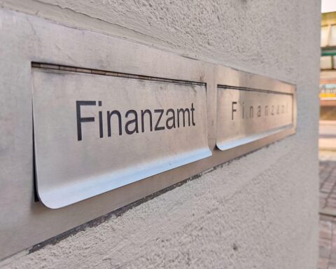 Finanzamt mit Dokumenten; Symbol für Steuerreform und Belastungen für Alleinverdiener-Ehen.