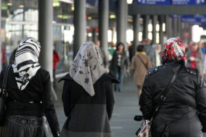 Vielfältige Frauen mit Kopftüchern, die Kultur und Einwanderungsgeschichte symbolisieren.