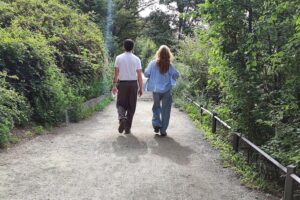 Mann und Frau spazieren, symbolisieren moderne Partnerschaft und gemeinsames Berufsleben ohne traditionelle Rollen.