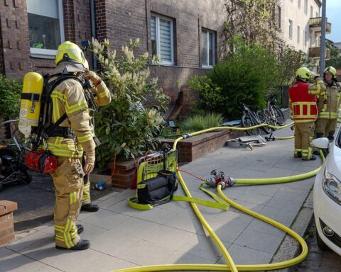 Kellerbrand in Mehrfamilienhaus, Feuerwehr im Einsatz, verletzte Personen, Rauch und Einsatzkräfte sichtbar.