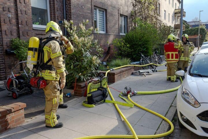 Kellerbrand in Mehrfamilienhaus, Feuerwehr im Einsatz, verletzte Personen, Rauch und Einsatzkräfte sichtbar.