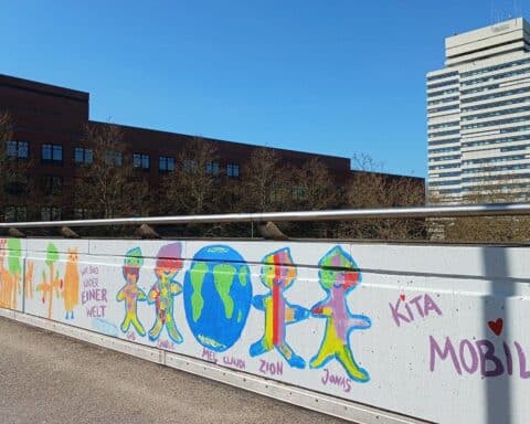Bunte Graffiti-Kunstwerke von Kindern auf der Fußgängerbrücke in Kaiserslautern.