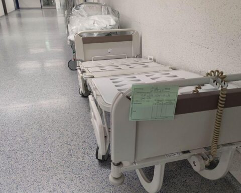 Krankenhaus mit Pflegepersonal, kritische Diskussion über Kosten, Gesetzgebung und Gesundheitssystem.