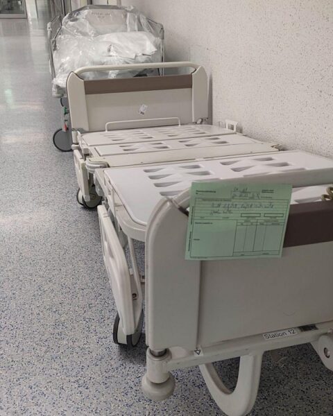 Krankenhaus mit Pflegepersonal, kritische Diskussion über Kosten, Gesetzgebung und Gesundheitssystem.