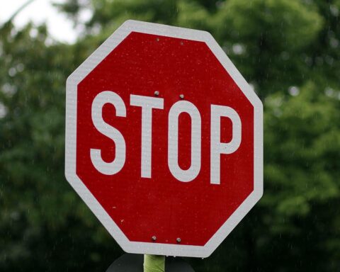 Ein Stoppschild mit Baustellensymbol, das die bevorstehende Straßensperrung ankündigt.