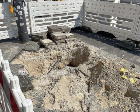 Baustelle mit Bauarbeiten an der Landesstraße, Absperrungen und Baustellenfahrzeugen sichtbar.