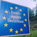 Grenzschild Deutschlands mit Hinweis auf temporäre Kontrollen und rechtliche Streitigkeiten zur Einreise.