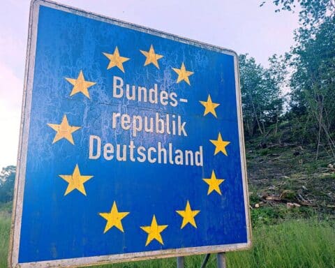 Grenzschild Deutschlands mit Hinweis auf temporäre Kontrollen und rechtliche Streitigkeiten zur Einreise.