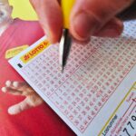 Lottoschein für "6 aus 49" mit gezogenen Zahlen und Glücksspielwarnung.