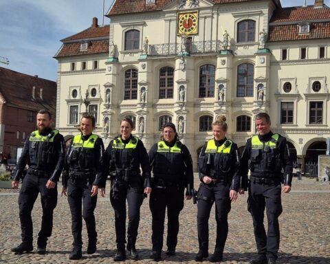 Sechs Polizeibeamte stehen zusammen, symbolisieren Sicherheit und Nähe zur Bevölkerung in Lüneburg.